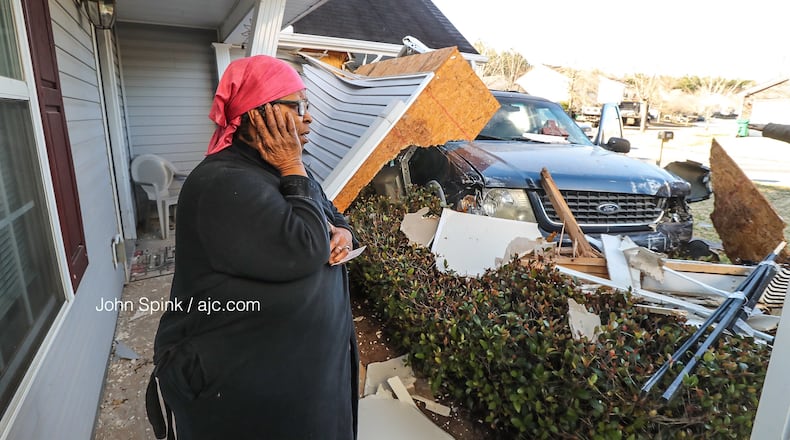 Carolyn Burgess surveys the damage after a stolen car crashed into her Browns Mill Ferry Road home Friday morning.