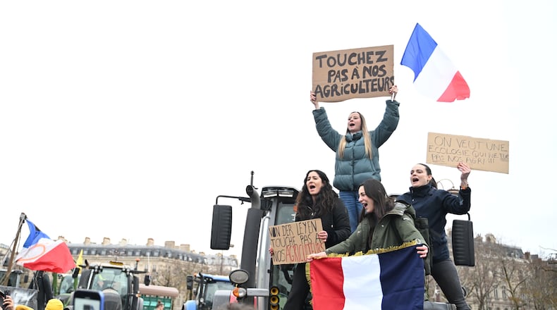 Women atop a tractor support farmers as they protest at the Arc de Triomphe against against the European Union's negotiations over the Mercosur trade deal with five South American nations, Thursday, Jan. 8, 2026 in Paris. (AP Photo/Emma Da Silva)