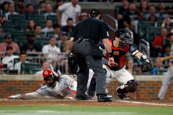 Cincinnati Reds' Elly De La Cruz (44) beats the throw to Atlanta Braves catcher Sean Murphy (12) as he slides safely into home plate during the eighth inning of a baseball game, Tuesday, May 6, 2025, in Atlanta. (AP Photo/Butch Dill)
