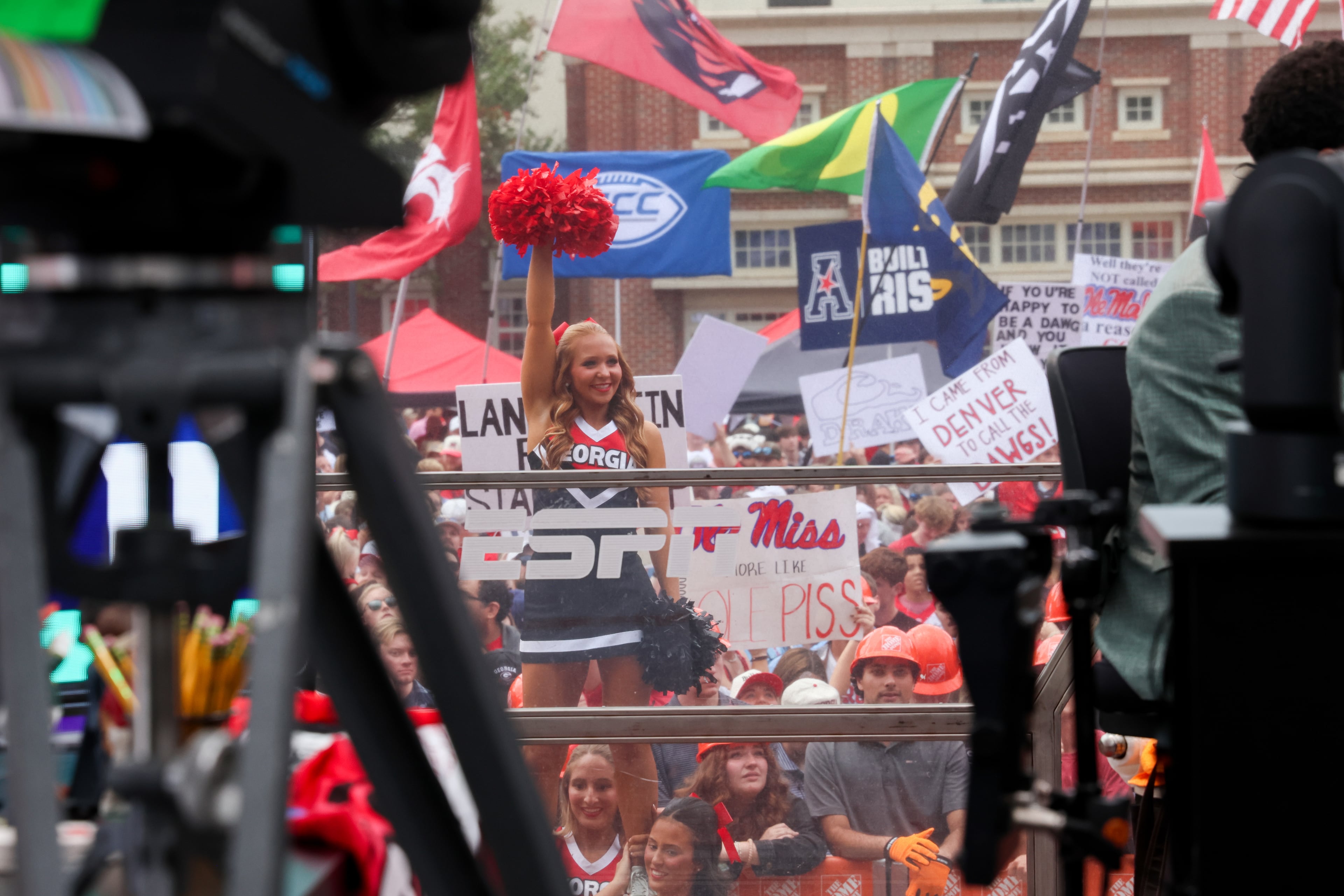 A UGA cheerleader pops up behind the set during the ESPN College GameDay broadcast from Myers Quad at UGA on Saturday, Oct. 18, 2025. (C.J. Bartunek for the AJC)