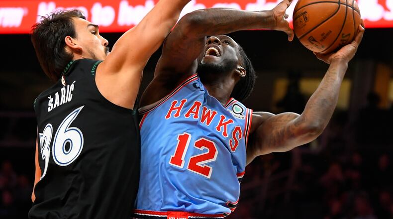 Hawks forward Taurean Prince (12) shoots as Minnesota Timberwolves forward Dario Saric defends on Wednesday, Feb. 27, 2019, in Atlanta. (AP Photo/John Amis)
