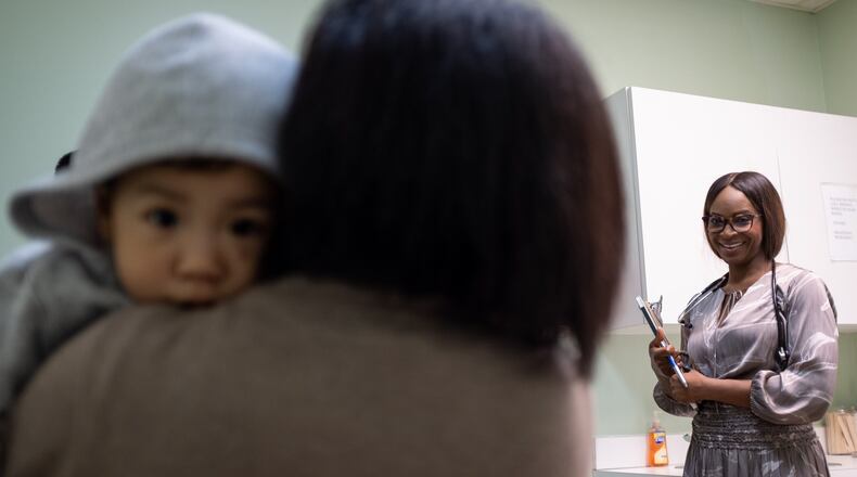 Dr. Iyabo Okuwobi, a Nigerian-American doctor in Decatur, talks with Niang Lun as she holds her 16-month-old son, Hau Tuang Lun, following an exam Feb. 24, 2020. The Lun family is from Myanmar, one of the countries affected by the Trump administration’s new travel restrictions. Ben Gray for The Atlanta Journal-Constitution