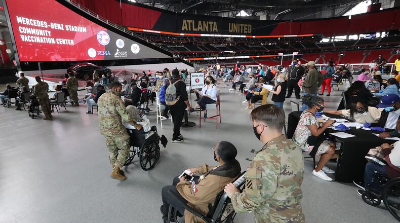 U.S. Army soldiers from Fort Stewart help some of the elderly through the process of getting their first vaccination at Mercedes-Benz Stadium, the state’s largest Community Vaccination Center on Wednesday, March 24, 2021 in Atlanta.  (Curtis Compton/Curtis.Compton@ajc.com)
