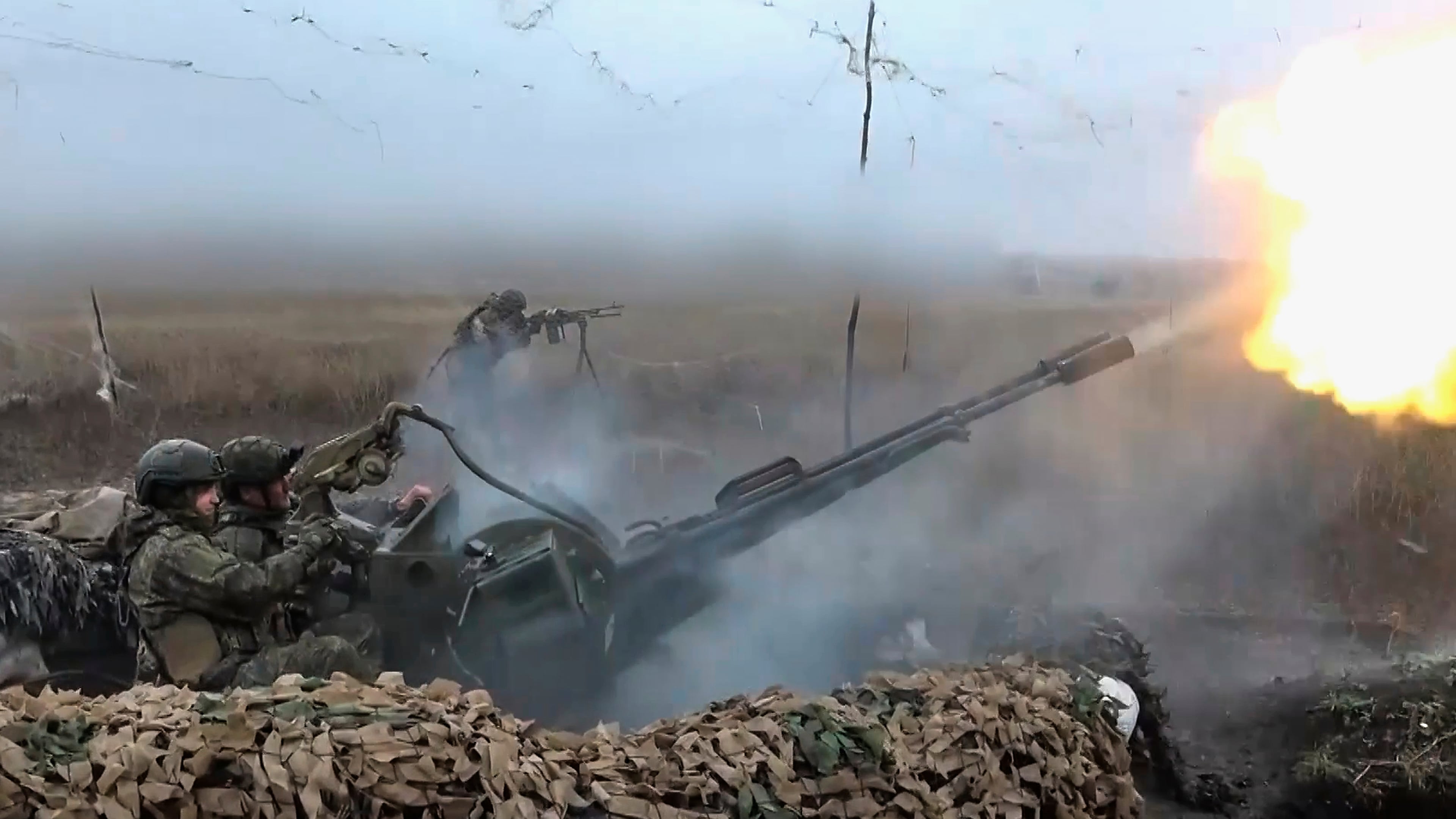 In this image made from video provided by Russian Defense Ministry Press Service on Friday, Nov. 7, 2025, Russian army soldiers fire to shoot a Ukrainian drone on an undisclosed location in Ukraine. (Russian Defense Ministry Press Service via AP)