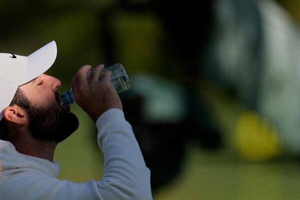 Scottie Scheffler drinks on the practice green during a practice round at the Masters golf tournament, Tuesday, April 8, 2025, in Augusta, Ga. (AP Photo/George Walker IV)