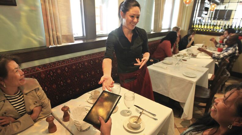Holly Wilmarth, a server at Pasha Grill in The Greene, delivers the check to a table of customers. (Fay Traylor, left and Marylou Pugh, both from out of the area). A business professor studied 9,000 credit card receipts recently and found that diners are tipping more than 20 percent, causing people in the industry to think a 25 percent tip is the new norm. is that really gonna fly in the midwest? in new york, waiters are absolutely expecting 25 percent. we talk to restaurant association, wait staff and diners on this debate. Staff photo by Jim Witmer