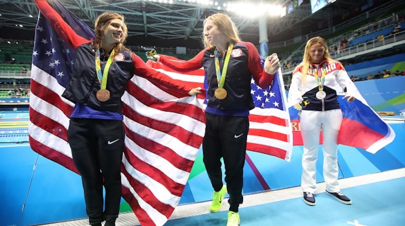 Women's 100-meter breaststroke winners Katie Meili (bronze), left, Lilly King (gold) and Yulia Efimova of Russia parade in front of photographers at the Olympic Aquatic Stadium at the Rio Olympic Games on August 9, 2016. (Robert Gauthier/Los Angeles Times/TNS)