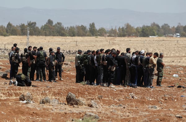 Syrian government security forces attend their noon prayer at Busra al-Harir village in Daraa, as they prepare to enter Sweida province where clashes erupted between Druze militias and Sunni Bedouin clans, southern Syria, Monday, July 14, 2025. (AP Photo/Omar Sanadiki)