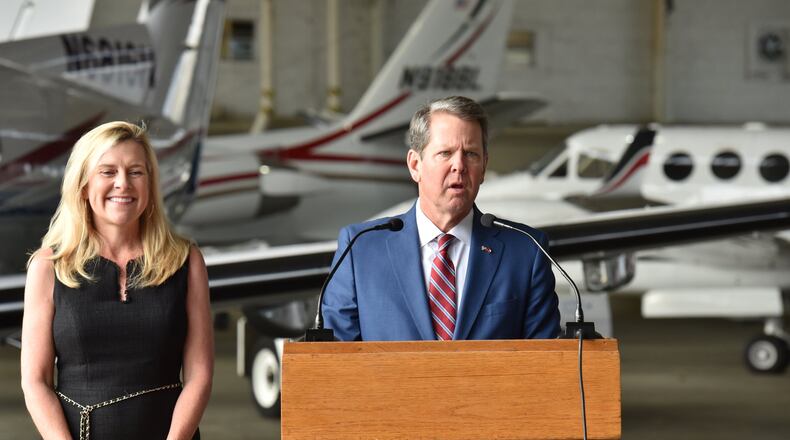 Gov. Brian Kemp, with first lady Marty Kemp, speaks Wednesday at DeKalb-Peachtree Airport as he starts a statewide tour to mark his first 100 days as Georgia’s 83rd governor. HYOSUB SHIN / HSHIN@AJC.COM