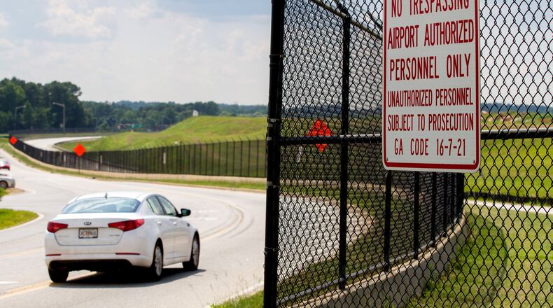 Cars drive by some of the 29.5 miles of fence that surround the Hartsfield-Jackson Atlanta International Airport July 10, 2018. STEVE SCHAEFER / SPECIAL TO THE AJC