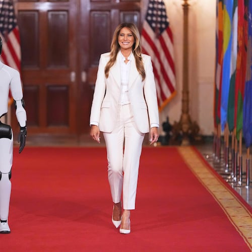 First lady Melania Trump arrives, accompanied by a robot, to attend the "Fostering the Future Together Global Coalition Summit," with other first spouses, at the White House, Wednesday, March 25, 2026, in Washington. (AP Photo/Jacquelyn Martin)