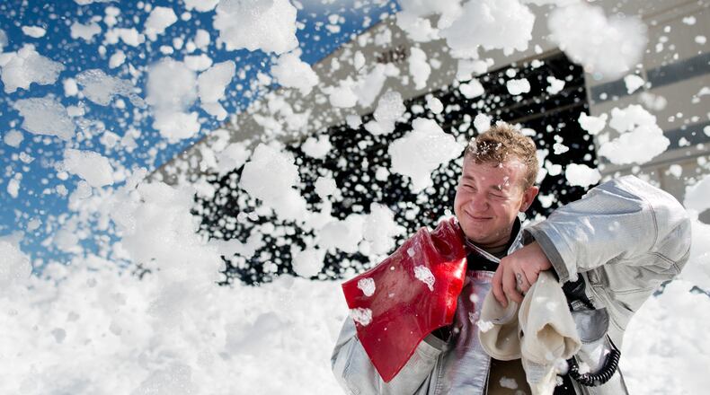 John Sherman, a 60th Engineer Squadron firefighter, is hit by fire-retardant foam in an aircraft hangar at Travis Air Force Base in California on Sept. 24, 2013. Firefighters with the 60th Air Mobility Wing helped control the foam’s dispersion using powerful fans and covering drains. (Ken Wright/U.S. Air Force)