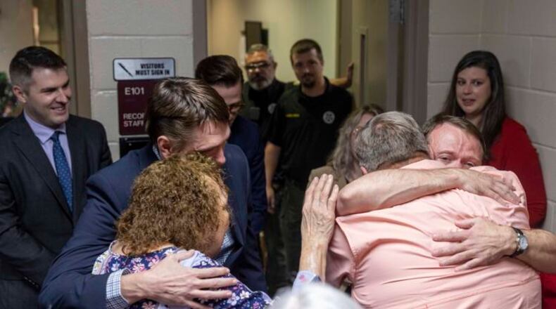 Josh Storey and Lee Clark hug family members as they're released from the Floyd County Jail after unjustly serving 25 years in prison for a murder they did not commit. (Photo Courtesy of Ryan Smith/Georgia Innocence Project)