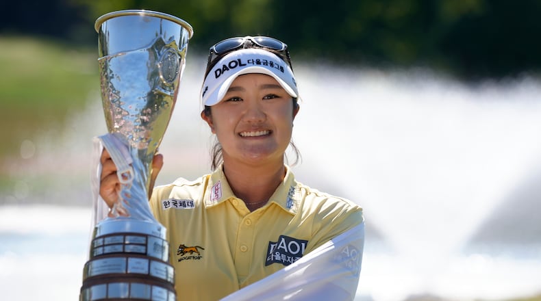 Haeran Ryu, of South Korea, celebrates with her trophy after winning the Evian Championship women's golf tournament, in Evian, eastern France, Sunday, July 12, 2026. (AP Photo/Laurent Cipriani)