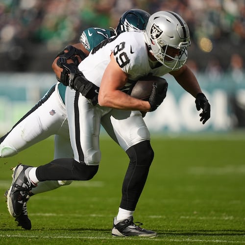Raiders tight end Brock Bowers (front) is brought down by then-Eagles linebacker Nakobe Dean. Dean was traded from Philadelphia to Las Vegas and will be Bowers’ teammate this season. (Matt Rourke/AP 2025)