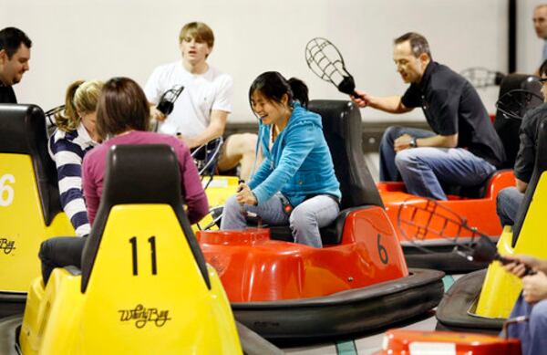 It's a lacrosse-like game. The object is to work a wiffle ball down a court using plastic scoops and score in the opposing team's goal, a nine-foot-high backboard with a hole in the middle. The game is played in special bumper cars known as whirlybugs. Yuting Cheng, center, battles fellow employees from Credigy, a financial services business, for the ball from her bumper car during a team building outing at Whirlyball Atlanta.
