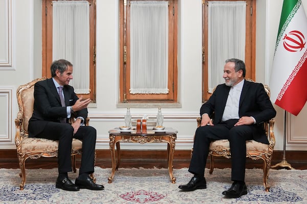 In this photo released by the Iranian Foreign Ministry, Foreign Minister Abbas Araghchi, right, listens to International Atomic Energy Agency (IAEA) Director General Rafael Mariano Grossi during their meeting in Tehran, Iran, Wednesday, April 16, 2025. (Iranian Foreign Ministry via AP)