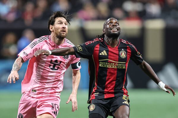 Inter Miami forward Lionel Messi (10) fights for position against Atlanta United midfielder Tristan Muyumba (8) during the second half of an MLS soccer match, Sunday, March 16, 2025, in Atlanta. (AP Photo/Colin Hubbard)