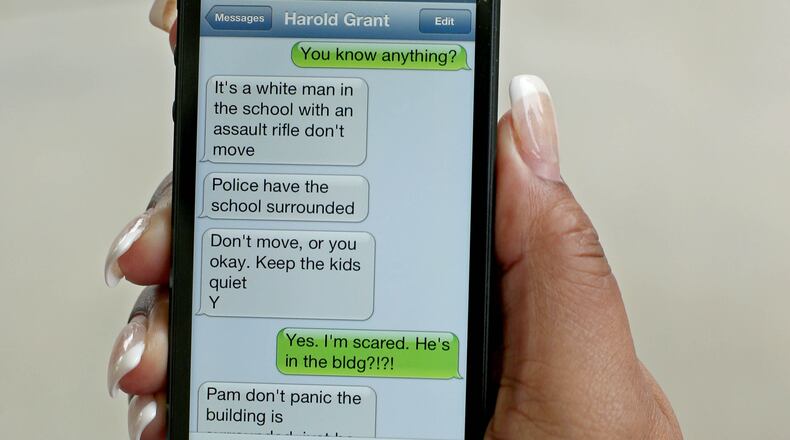 McNair Learning Academy fifth-grade teacher Pamela James shows a text message she received from the school's media specialist Harold Grant during the standoff at McNair Learning Academy shown at McNair High School on Wednesday morning in Atlanta.