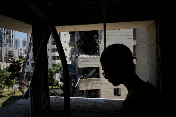 A man inspect the damage to a residential building hit by a missile launched from Iran, in Petah Tikva, Israel, Monday, June 16, 2025. (AP Photo/Baz Ratner)