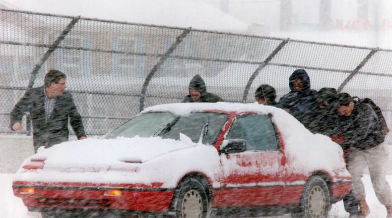 This file photo from March 13, 1993, shows good Samaritans lending a hand to a stuck motorist. That day was the snowiest in the history of Cobb County.
