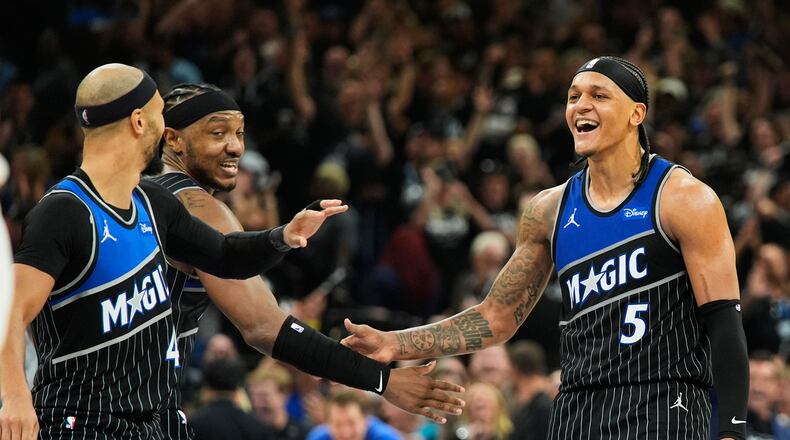 Orlando Magic forward Paolo Banchero (5) celebrates with teammates guard Jalen Suggs, left, and center Wendell Carter Jr. after sinking a 3-point shot against the Detroit Pistons during the closing moments of the second half in Game 3 of a first-round NBA basketball playoff series, Saturday, April 25, 2026, in Orlando, Fla. (AP Photo/John Raoux)