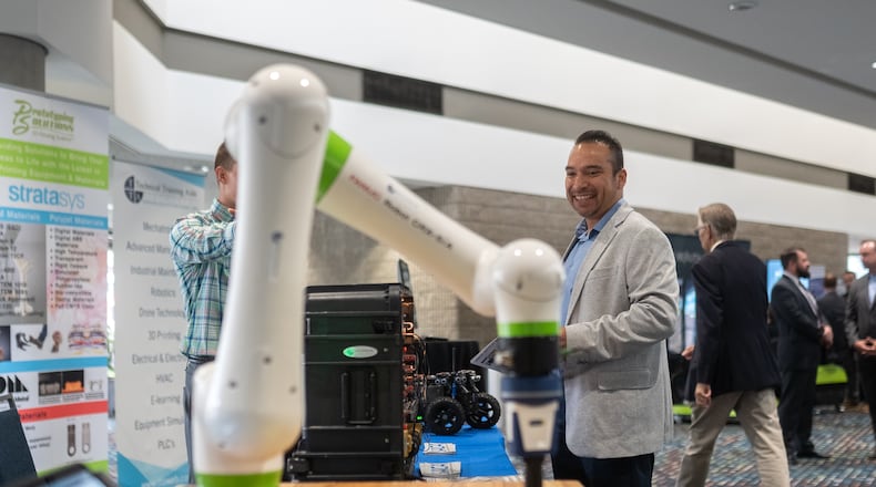 A man looks at a robotic arm being demoed. Georgia Governor Brian Kemp gives the key note address at the Governor's Workforce Summit held at the Georgia World Congress Center. Friday, Sept. 13, 2024 (Ben Hendren for the Atlanta Journal-Constitution)