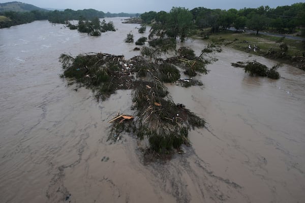 A raging Guadalupe River leaves fallen trees and debris in its wake, Friday, July 4, 2025, in Kerrville, Texas. (AP Photo/Eric Gay)