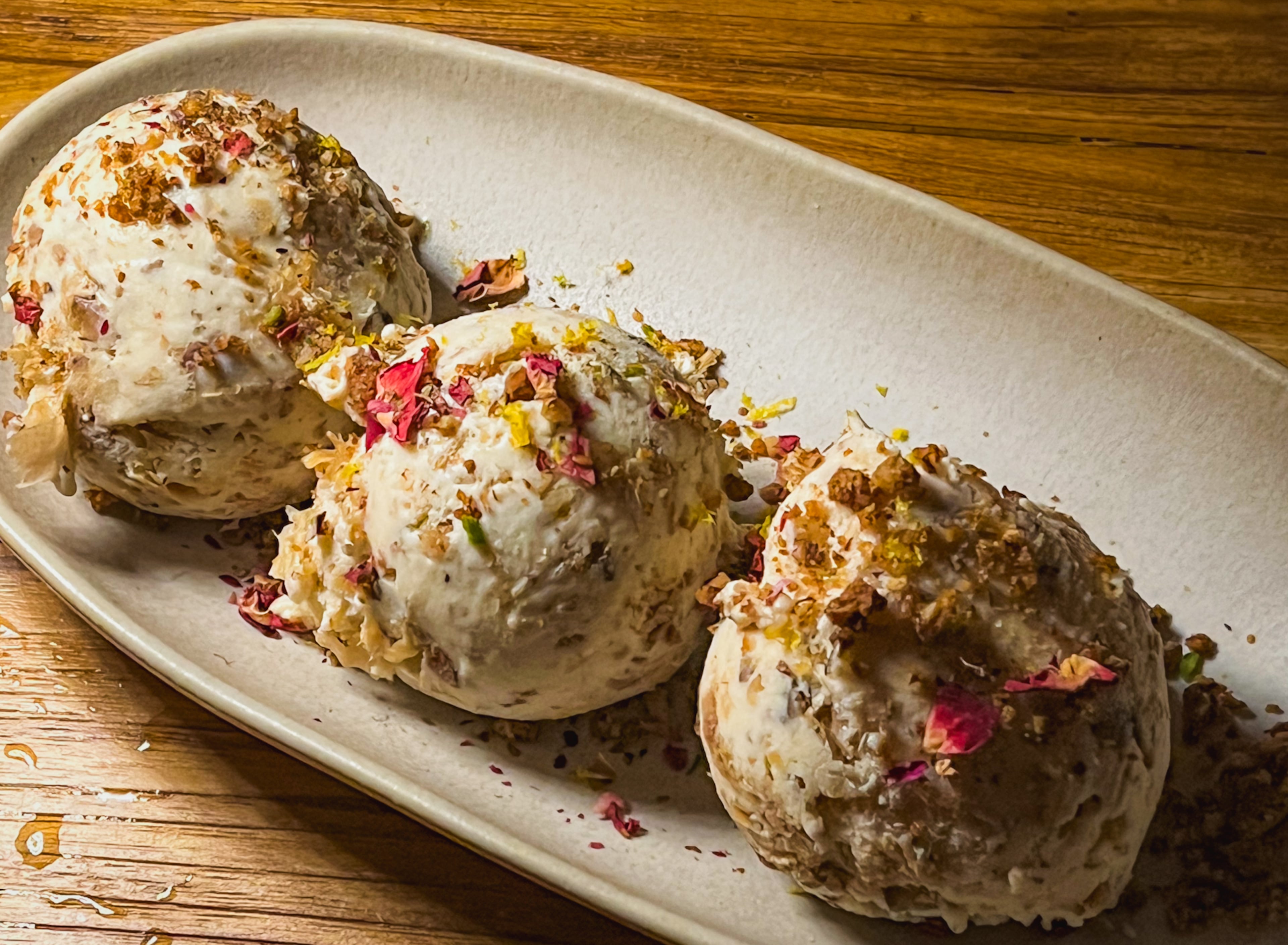 Baklava ice cream, not to be confused with the baklava (which is served with a different ice cream), is layered with honeyed phyllo, pistachios and rose petals at Delbar. (Henri Hollis/AJC 2023)