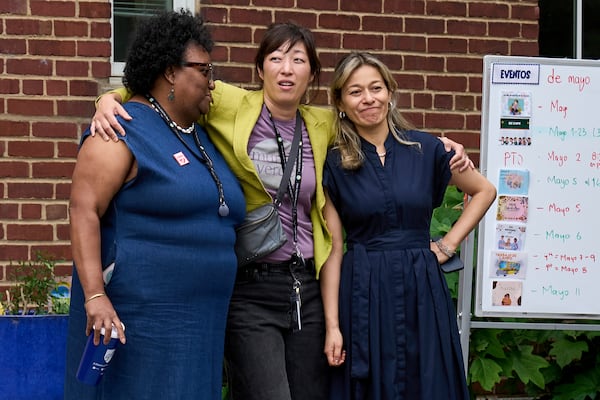 Staff at Mundo Verde Public Charter School hug as staff and parents keep watch for Immigration and Customs Enforcement (ICE) agents amid fears of impending arrests at schools, Tuesday, May 6, 2025. (AP Photo/Jacquelyn Martin)