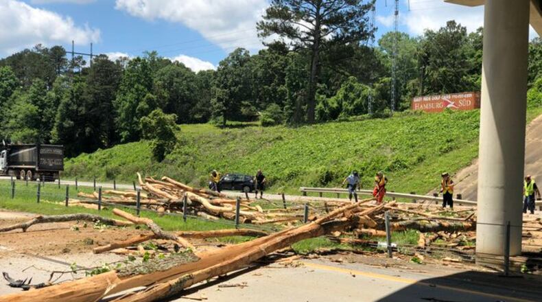 Logs were spread across part of I-575 after a tractor-trailer overturned, spilling its cargo on the interstate.
