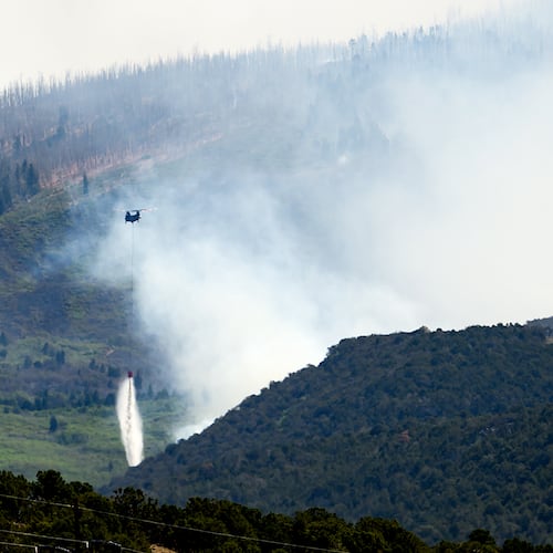 A helicopter drops water on the Cottonwood Fire burning near Beaver, Utah, on Saturday, June 27, 2026. (AP Photo/Noah Berger)