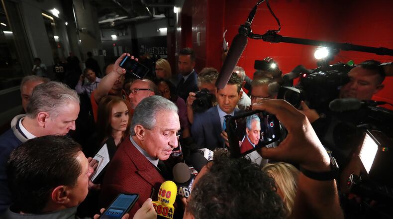 Falcons owner Arthur Blank is surrounded by media.