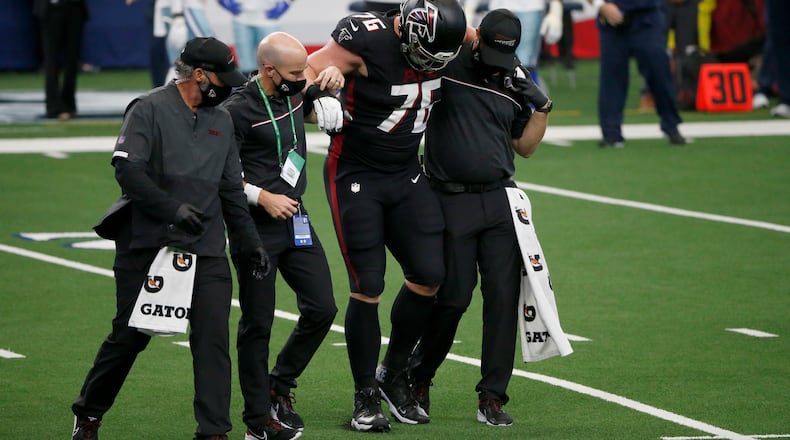 Falcons offensive guard Kaleb McGary (76) is helped off the field after suffering a knee injury during the first half Sunday, Sept. 20, 2020, against the Dallas Cowboys in Arlington, Texas. (Michael Ainsworth/AP)
