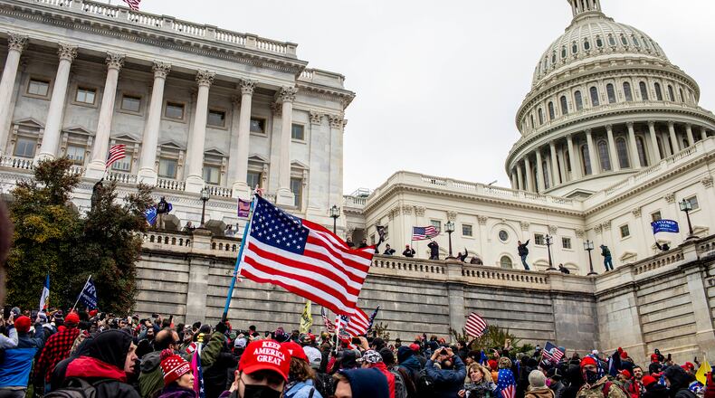 Protestors storm the Senate side of the Capitol on Jan. 6, 2021 after a rally at which President Donald Trump spoke. At least 30 law enforcement officers from around the country took part in the rally that preceded the riot. (Jason Andrew/The New York Times)