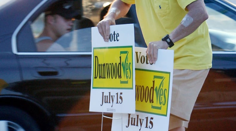 Ken Curry puts out pro-cityhood signs at the corner of Shallowford and Chamblee-Dunwoody roads before the community voted to incorporate as a city in July 2008.