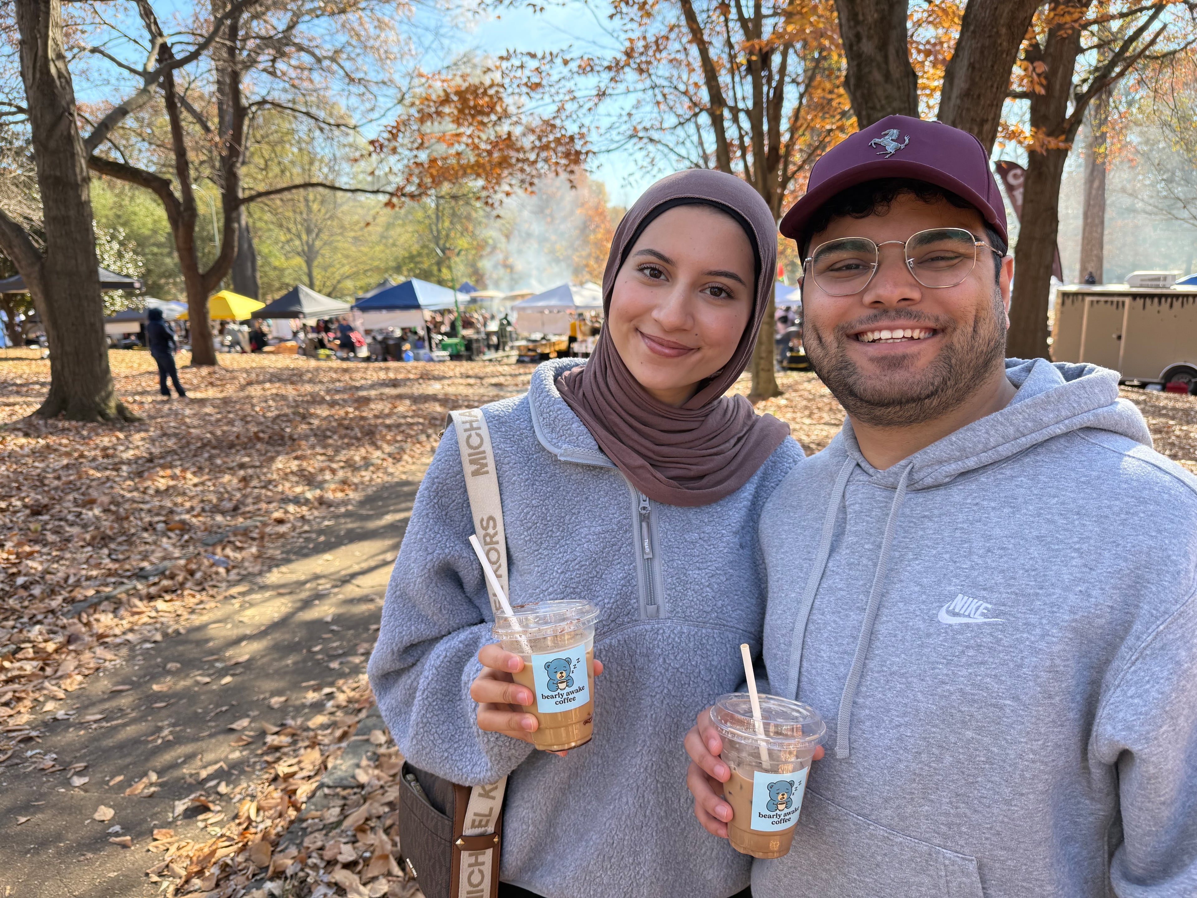 Newlyweds Layan Awad, left, and Othman Awad, right, came to the Atlanta Halal Fall Festival on November 23, 2025 and are seen here enjoying their coffee drinks from Bearly Awake Coffee. Photo by Ariel Hart ahart@ajc.com