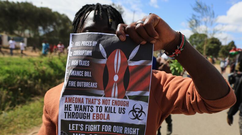 A protester holds up a placard during a demonstration against a proposed Ebola quarantine center to be established by the United States at Laikipia Air Base in Nanyuki, Kenya, Monday, June 1, 2026. (AP Photo/Andrew Kasuku)