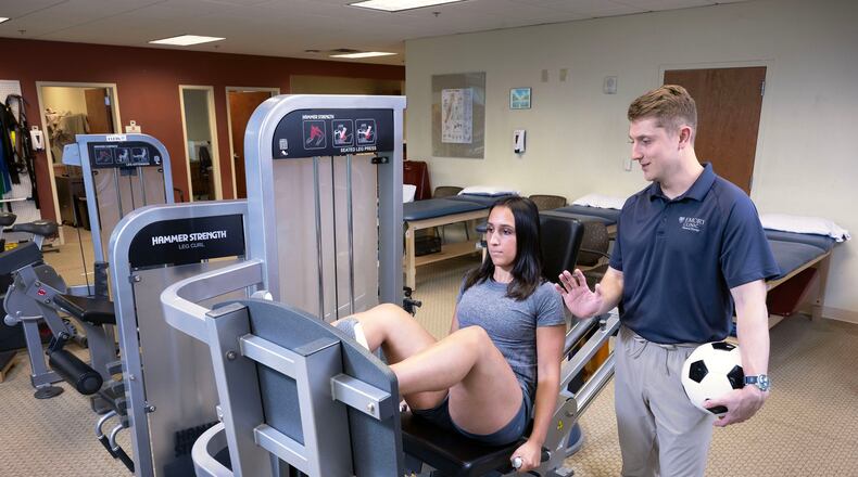 Sports medicine physical therapist Carl Guidry (right) trains Katherine Kutscera at Emory Johns Creek Hospital. (Jack Kearse/Courtesy of Emory University)