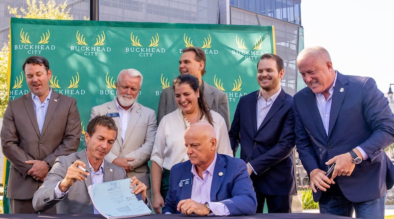 State Sen. Greg Dolezal (seated, left), signs onto the bill in support of Buckhead cityhood, alongside Sen. Brandon Beach (seated) and other state senators and cityhood supporters. (Jenni Girtman for The Atlanta Journal-Constitution)