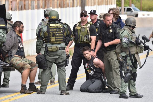 Daniel Hanley, kneeling, and another counterprotester are held by police as the National Socialist Movement rally at Greenville Street Park in downtown Newnan on Saturday, April 21, 2018. They sued Coweta County and police for violating their civil rights. (Hyosub Shin/AJC)