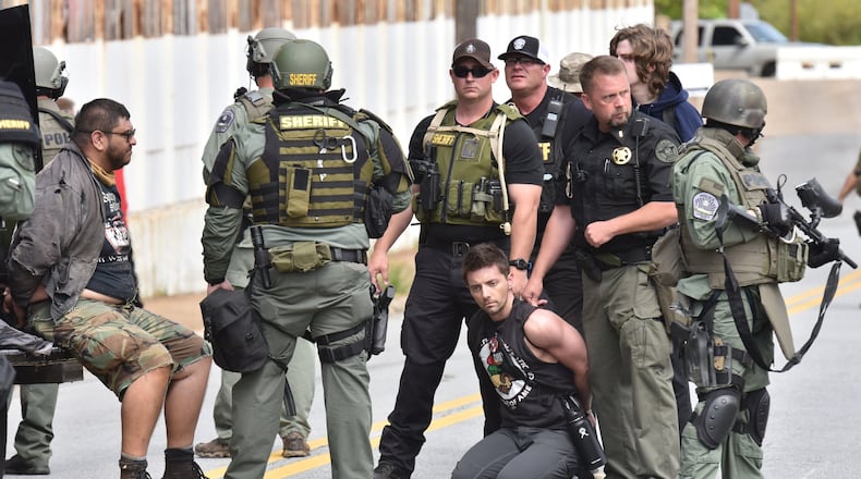 Counterprotesters are held by police as the National Socialist Movement held a rally at Greenville Street Park in downtown Newnan on Saturday, April 21, 2018. Daniel Hanley, kneeling, and another counterprotester are now suing Coweta County and police for violating their civil rights. HYOSUB SHIN / HSHIN@AJC.COM
