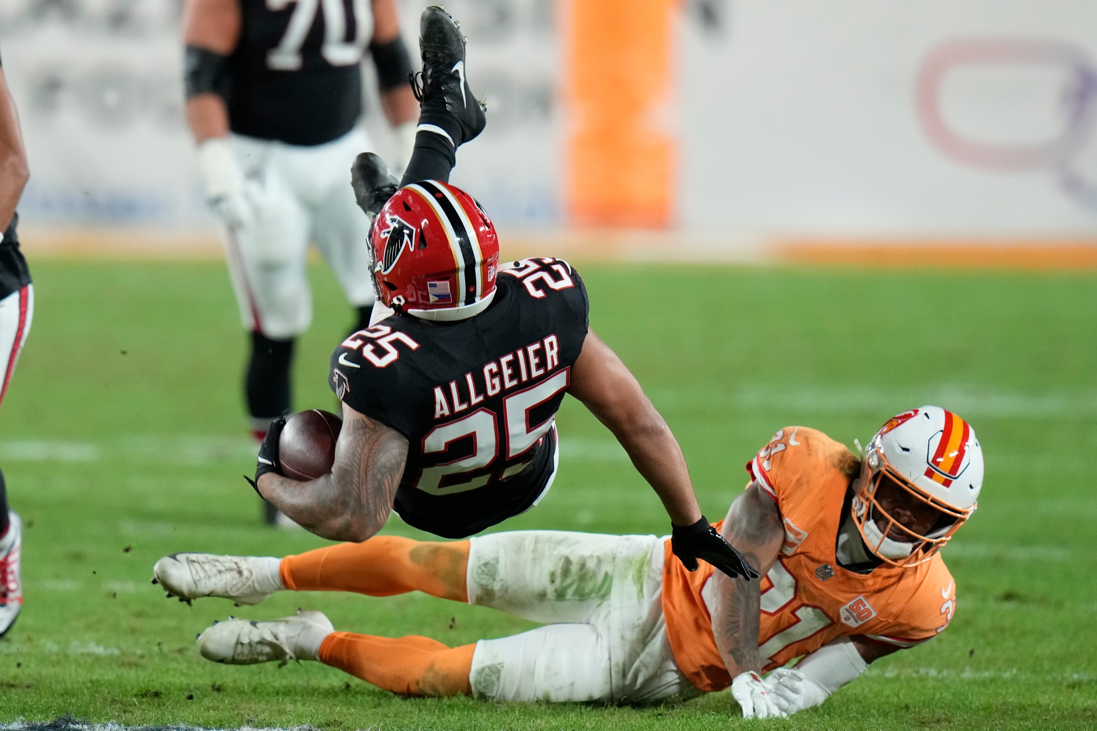 Tampa Bay Buccaneers cornerback Benjamin Morrison (21) tackles Atlanta Falcons running back Tyler Allgeier (25) during the second half of an NFL football game, Thursday, Dec. 11, 2025, in Tampa, Fla. (AP Photo/Chris O'Meara)