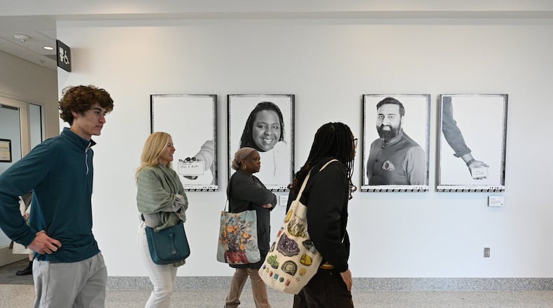 Campus tour participants pass by photographs from a new mental health campaign at the Emory University Student Center on Thursday, Feb. 8, 2024, in Atlanta. The campaign aims to combat toxic perfectionism by showing students examples of faculty, staff and alumni and their personal stories of learning from setbacks and failures. (Hyosub Shin / Hyosub.Shin@ajc.com)