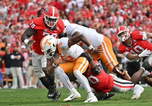 Tennessee quarterback Hendon Hooker is brought down by Georgia defensive lineman Tramel Walthour (90). (Hyosub Shin / Hyosub.Shin@ajc.com)