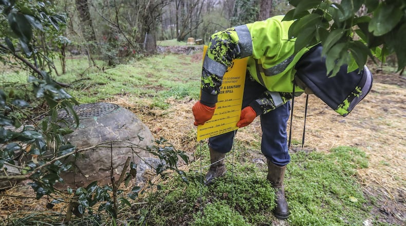 A DeKalb County Watershed worker posts sewage spill notifications on along Miriam Lane near Gena Drive in Decatur, where frequent sewage overflow occurrences have been cited. DeKalb County is still tackling ongoing sewer issues since CEO Michael Thurmond took over in 2017. DeKalb County is under a federal consent decree to repair its aging and overwhelmed wastewater system and has dedicated more than $300 million to the cause in recent years. JOHN SPINK/JSPINK@AJC.COM