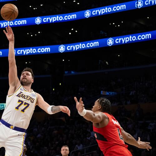 Los Angeles Lakers guard Luka Doncic (77) shoots over Toronto Raptors guard Ochai Agbaji (30) during the first half of an NBA basketball game in Los Angeles, Sunday, Jan. 18, 2026. (AP Photo/Kyusung Gong)