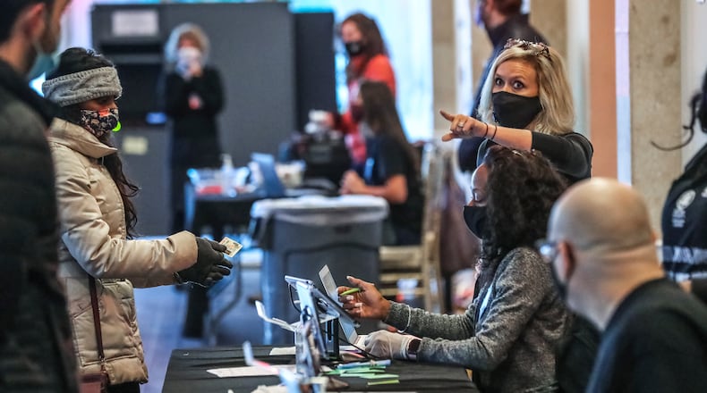 November 3, 2020 Atlanta: Poll worker Lauren Smith points the way at Park Tavern in Atlanta on Tuesday, Nov. 3, 2020. Voters lined up outside polling places Tuesday morning to be among the first to cast their votes on a crucial Election Day. It’s expected to be the biggest day of voting in Georgia, with turnout reaching as high as 2 million. Another 3.9 million people already cast early or absentee ballots. Some told The Atlanta Journal Constitution that they expect social unrest whether Biden or Trump wins the election. (John Spink / John.Spink@ajc.com)