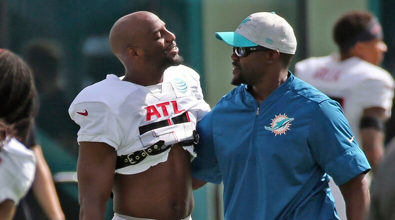Falcons cornerback Duron Harmon (left) and Dolphins coach Brian Flores greet one another during a joint training camp practice at the Dolphins training facility Wednesday, Aug. 18, 2021, in Miami Gardens, Fla.  (Charles Trainor Jr./Miami Herald)