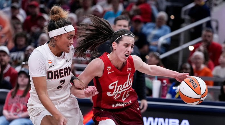 Indiana Fever guard Caitlin Clark (22) drives on Atlanta Dream guard Te-Hina Paopao (2) in the first half of a WNBA basketball game in Indianapolis, Thursday, June 18, 2026. (AP Photo/Michael Conroy)
